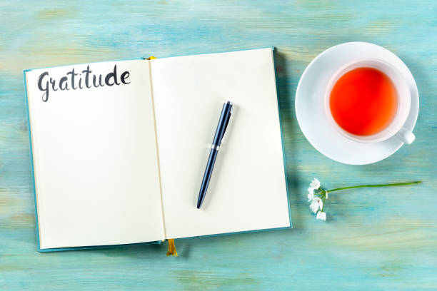 Journal and pen beside a cup of herbal tea for gratitude writing